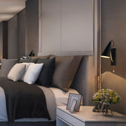 A sleek black and gold wall light provides ambient illumination in this modern bedroom setting.