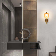 Stylish interior lighting: a warm, amber wall sconce adds character next to an illuminated panel and a modern display shelf.