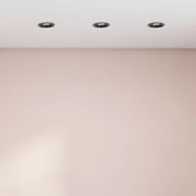 A clean interior view featuring three recessed ceiling lights illuminating a room with a soft, neutral wall colour.