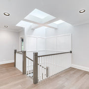 Bright lighting design with recessed ceiling lights and skylights creating a modern and airy atmosphere in this hallway.