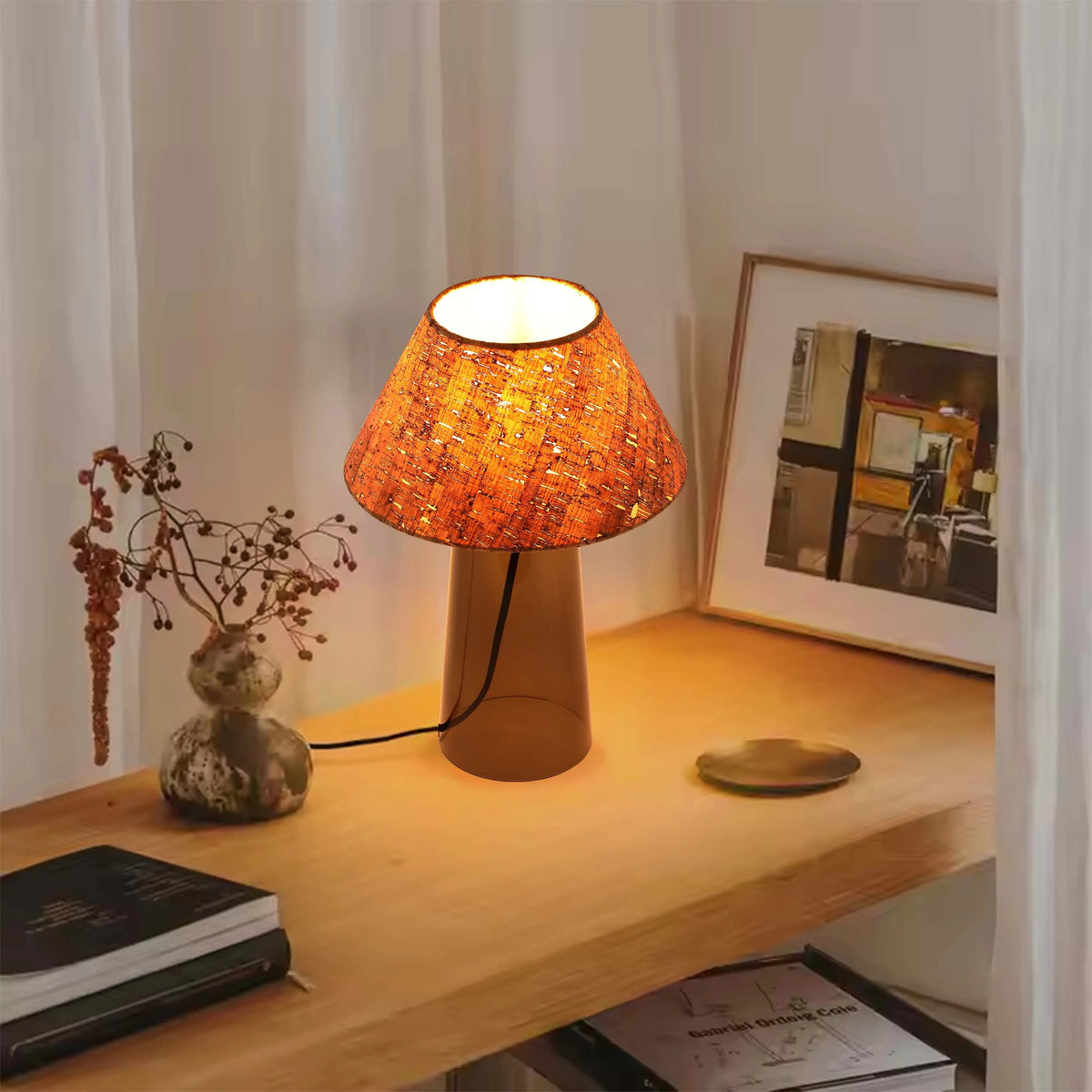 A glowing, orange table lamp with a textured shade adds a cosy warmth to this interior scene.
