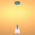 A hanging pendant light with a clear glass shade and a green mount against an orange background.