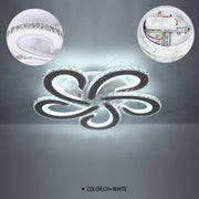 A crystal and chrome five-light ceiling light with a unique swirl design and circular details. Colour: chrome and white.