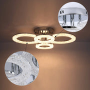 A modern ceiling light with multiple illuminated crystal rings creates an inviting glow.