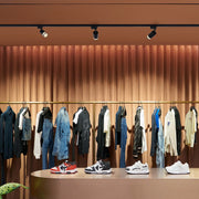 Track lighting illuminates a clothes rack. The sleek, directional spotlights provide focused and adjustable illumination for a modern look.