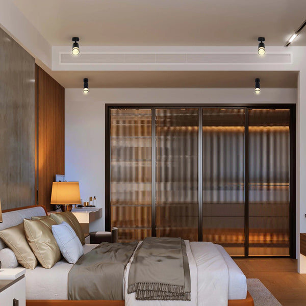 Bedroom with track lighting and spotlights provide a modern, stylish illumination, enhancing the room's warm and inviting ambience.