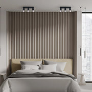Bedroom with two sets of spotlights on the ceiling, illuminating the textured wooden wall and headboard.