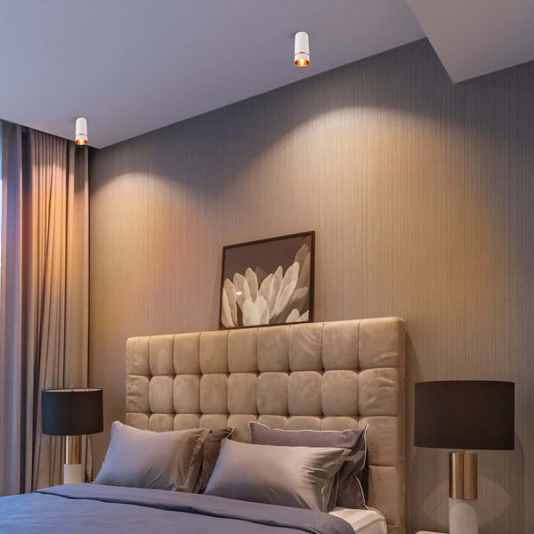 Bedroom lighting features recessed ceiling lights, providing warm illumination. Bedside lamps add a soft glow, complementing the serene ambience.
