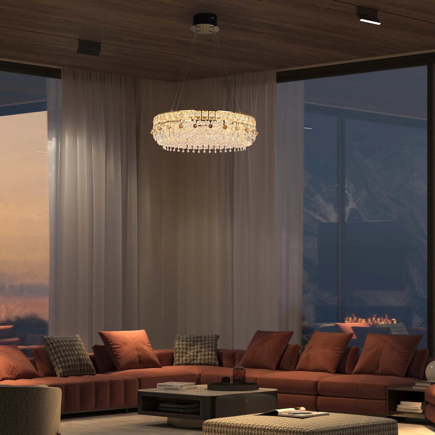 A modern living room showcases a dazzling crystal chandelier, complemented by sleek track lighting on the wooden ceiling.