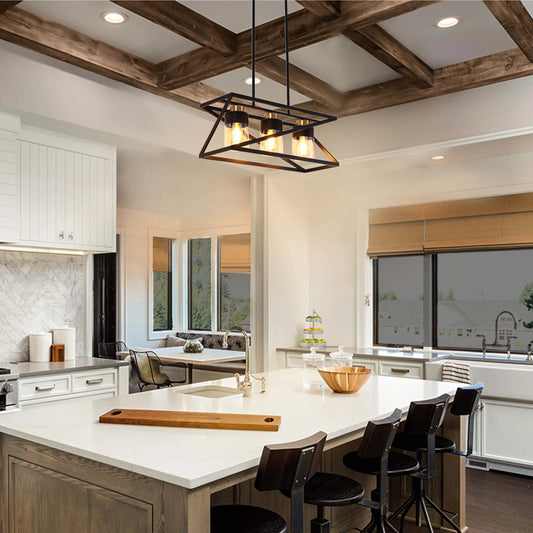 A stylish kitchen is illuminated by a geometric pendant light with three vintage-style bulbs, hanging above a kitchen island.