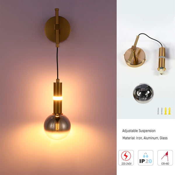 Gold wall lamp with round smoked glass shade, emitting a warm glow. Adjustable design made from iron, aluminium, and glass.