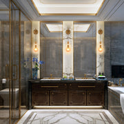 A lavish bathroom with statement lighting. Two wall sconces with exposed bulbs light the vanity area.