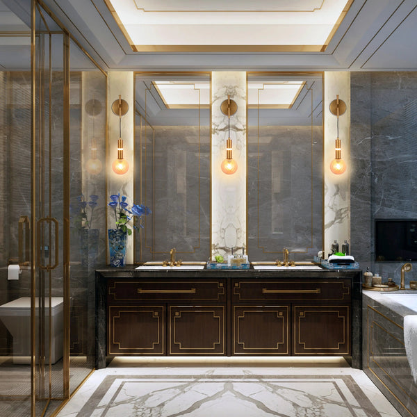 A lavish bathroom with statement lighting. Two wall sconces with exposed bulbs light the vanity area.