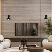 Two black, vintage-style wall lights illuminate a contemporary living room, adding a touch of industrial chic to the interior design.