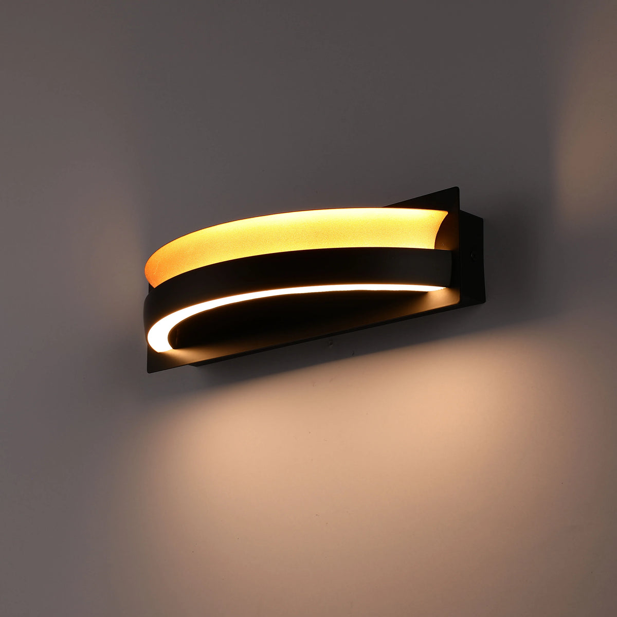 A modern wall light with curved black metal and warm, inviting light. Creates a cosy ambience and elegant design feature.