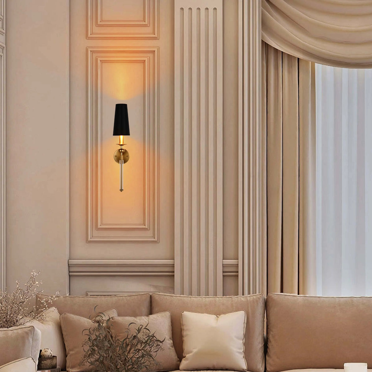 Wall-mounted sconce lamp with a sleek gold finish and a black shade, casting a warm glow against a panelled wall.