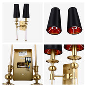 Gold wall light fixture featuring two black lamp shades with red interiors and decorative clear glass accents.