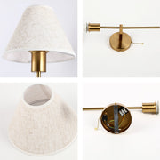 A brass wall light with a linen lampshade and pull switch.