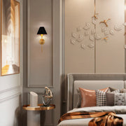 Elegant bedroom wall lighting: a sleek black and gold sconce adding a touch of modern sophistication to the stylish bedroom decor.