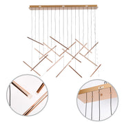 A contemporary pendant light featuring copper tubes suspended from a rectangular golden base with black cords.