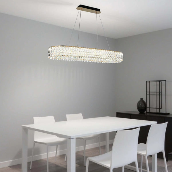 A modern crystal chandelier hangs above a dining table. The fitting has a rectangular shape and offers a touch of glamour to the room.