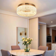 A modern, circular, crystal chandelier hangs in a dining room, creating a luxurious atmosphere.