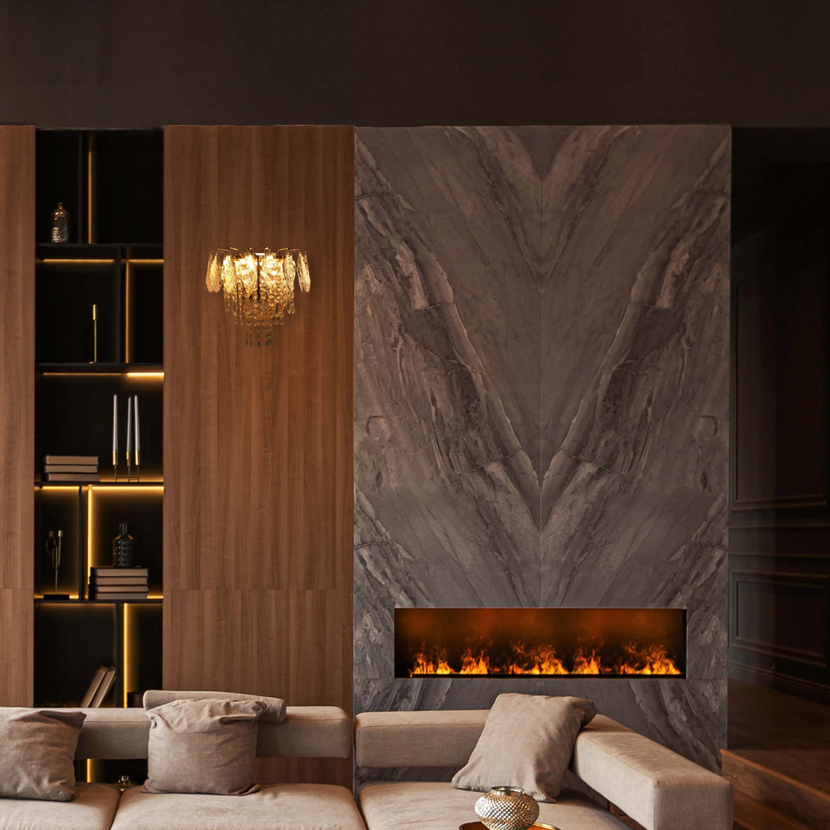 Chandelier and shelf lighting illuminate this space. Fire effect lighting gives a warm glow, offset by the cool marble backdrop.