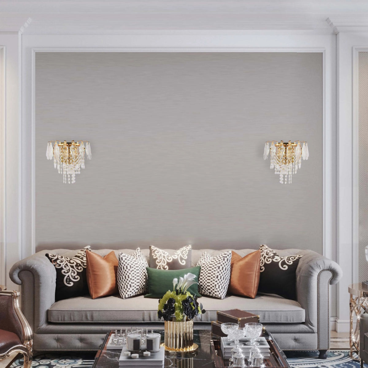 Crystal wall sconces add an elegant touch to this room, flanking a sofa with decorative pillows and marble-topped coffee table.