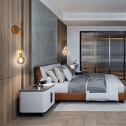 Bedroom with modern wall lamps. Features a brass finish & a glass globe creating a warm, inviting ambience.