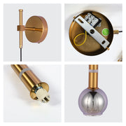 Contemporary wall light with a metallic gold finish and spherical glass lampshade, providing stylish ambient lighting.