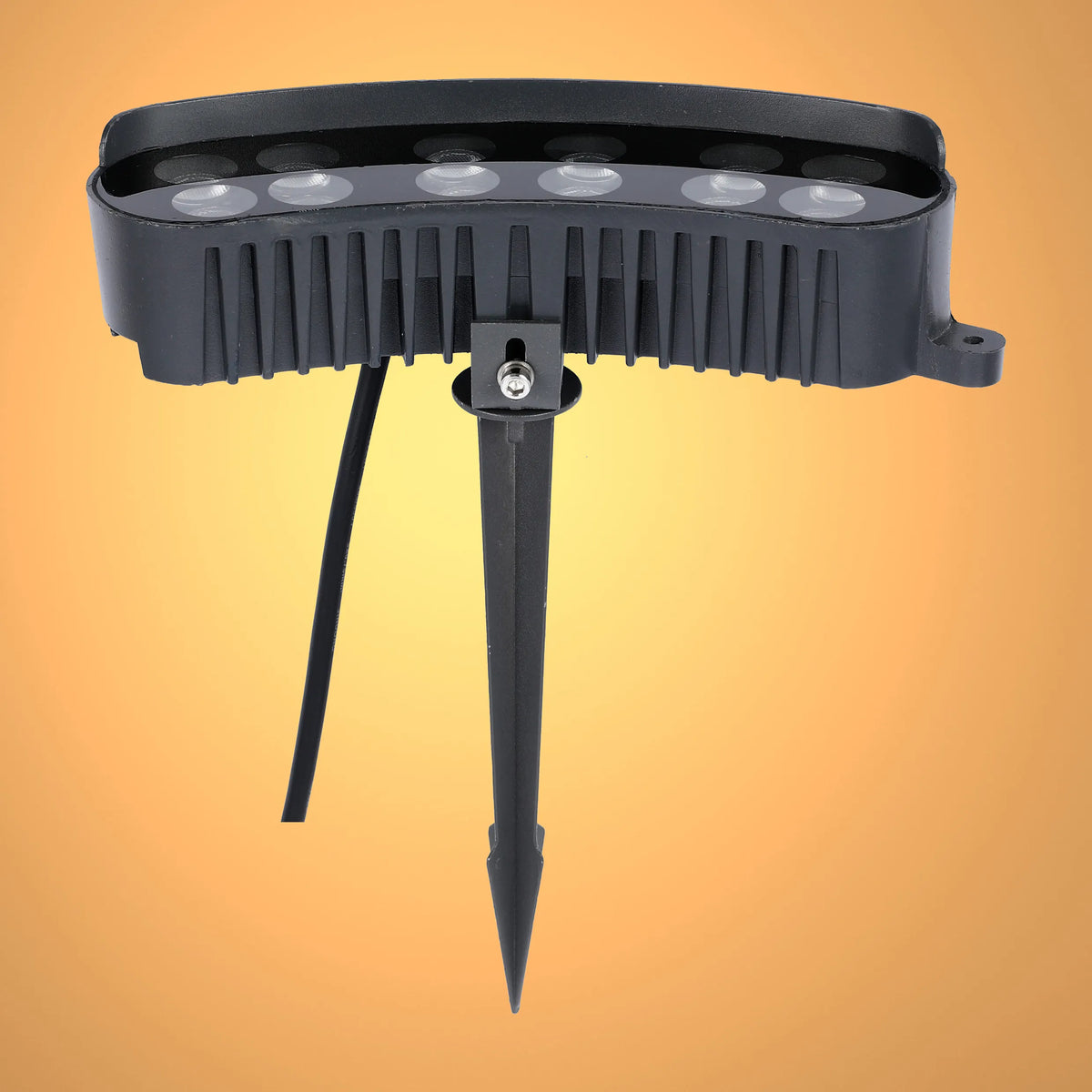 Black outdoor LED spotlight with ground spike, set against a gradient yellow backdrop, showcasing outdoor garden lighting.