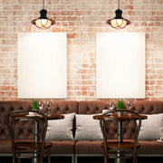 Ambient lighting from two industrial pendant lights hangs above tables set for two, enhancing the warm, inviting pub setting.