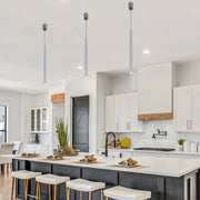 Three modern silver tube lights hang above the kitchen island, adding a touch of minimalist elegance to the space.