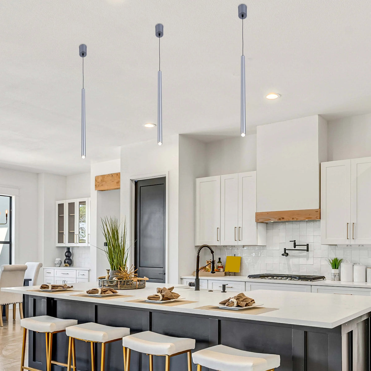 Three modern silver tube lights hang above the kitchen island, adding a touch of minimalist elegance to the space.