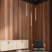 Three pendant lights hang from a dark ceiling. The lights are cylindrical and silver, adding a modern touch to the room.