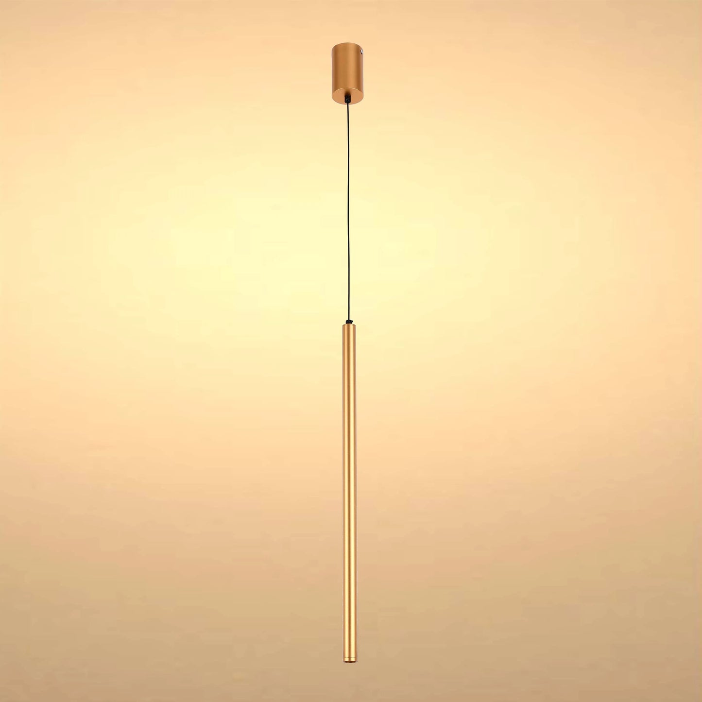 A modern, minimalist gold pendant light fixture with a long, slender cylindrical shade suspended from a black cable.