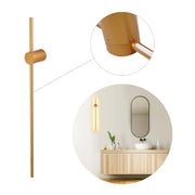 A gold finish modern LED wall light with a circular mid-section and rod design. Also seen installed in a bathroom setting.