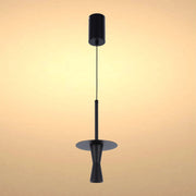A stylish matte black pendant light hangs against a warm cream background, a striking addition to any modern interior.
