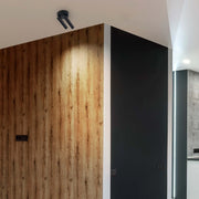 Modern interior lighting featuring a sleek, black track spotlight and ambient LED strip lighting highlighting architectural features.