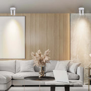 Contemporary room lighting features ceiling-mounted fixtures that are positioned to cast warm light on artwork and marble panelling.