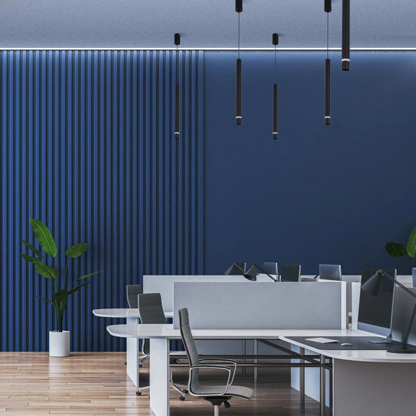 Pendant lighting in a modern office space, with cylindrical shades suspended from the ceiling.