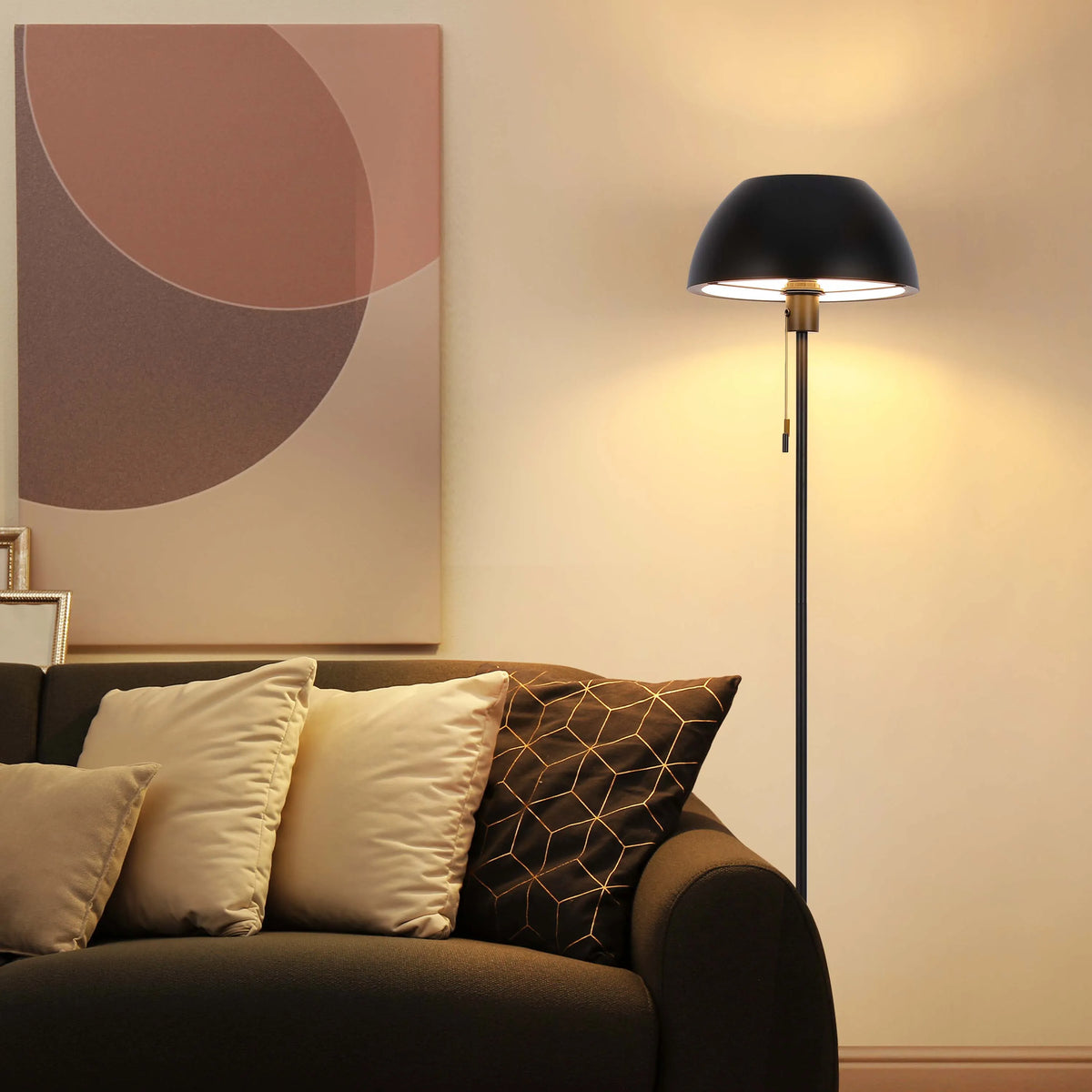 Warm, ambient lighting from a dome floor lamp illuminates a modern living space, highlighting soft cushions and artwork.