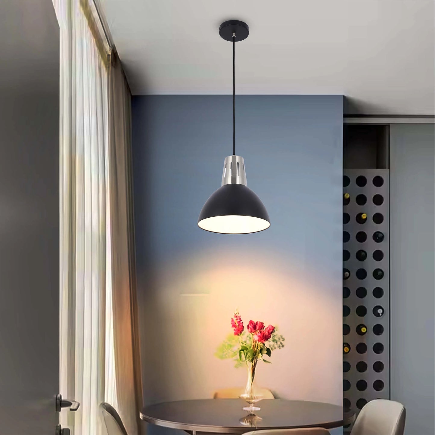 A stylish black pendant light casts a warm glow over a modern dining area, creating a welcoming and inviting atmosphere.