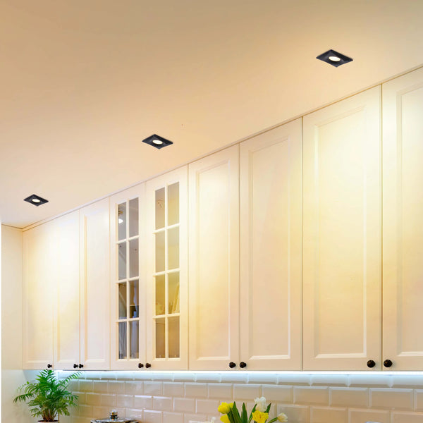 Stylish kitchen with square, recessed ceiling lights and under-cabinet lighting providing bright, modern illumination.