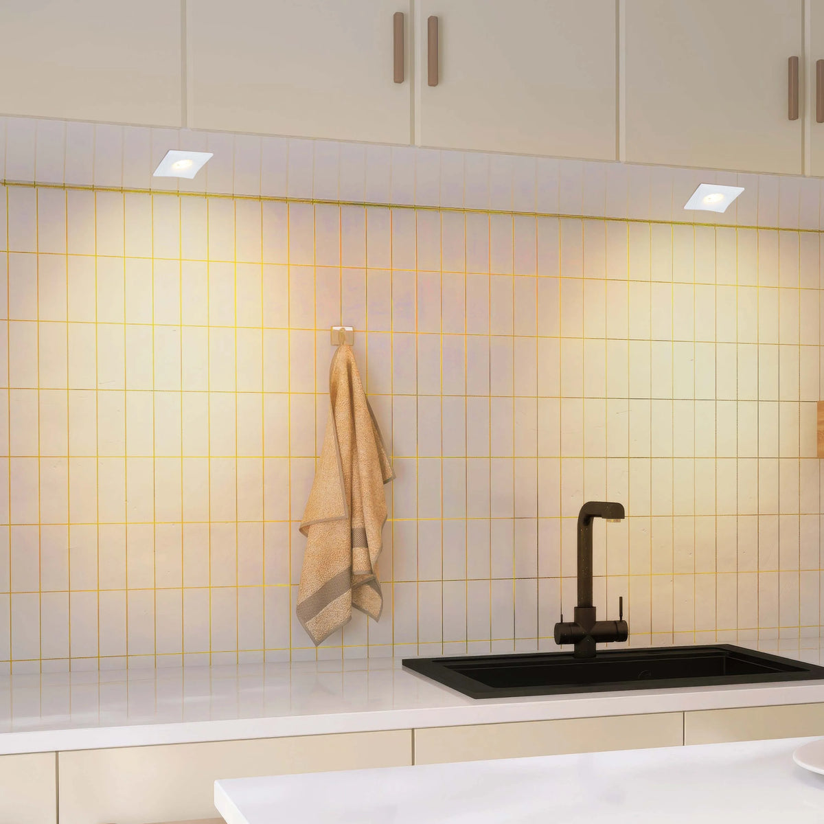 Kitchen features recessed downlights that give a bright, even ambient glow over the sink and splashback area.