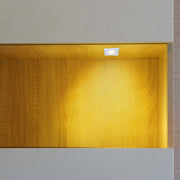 Warm, inviting light from a recessed spotlight illuminates a niche, creating a cosy and stylish display space.