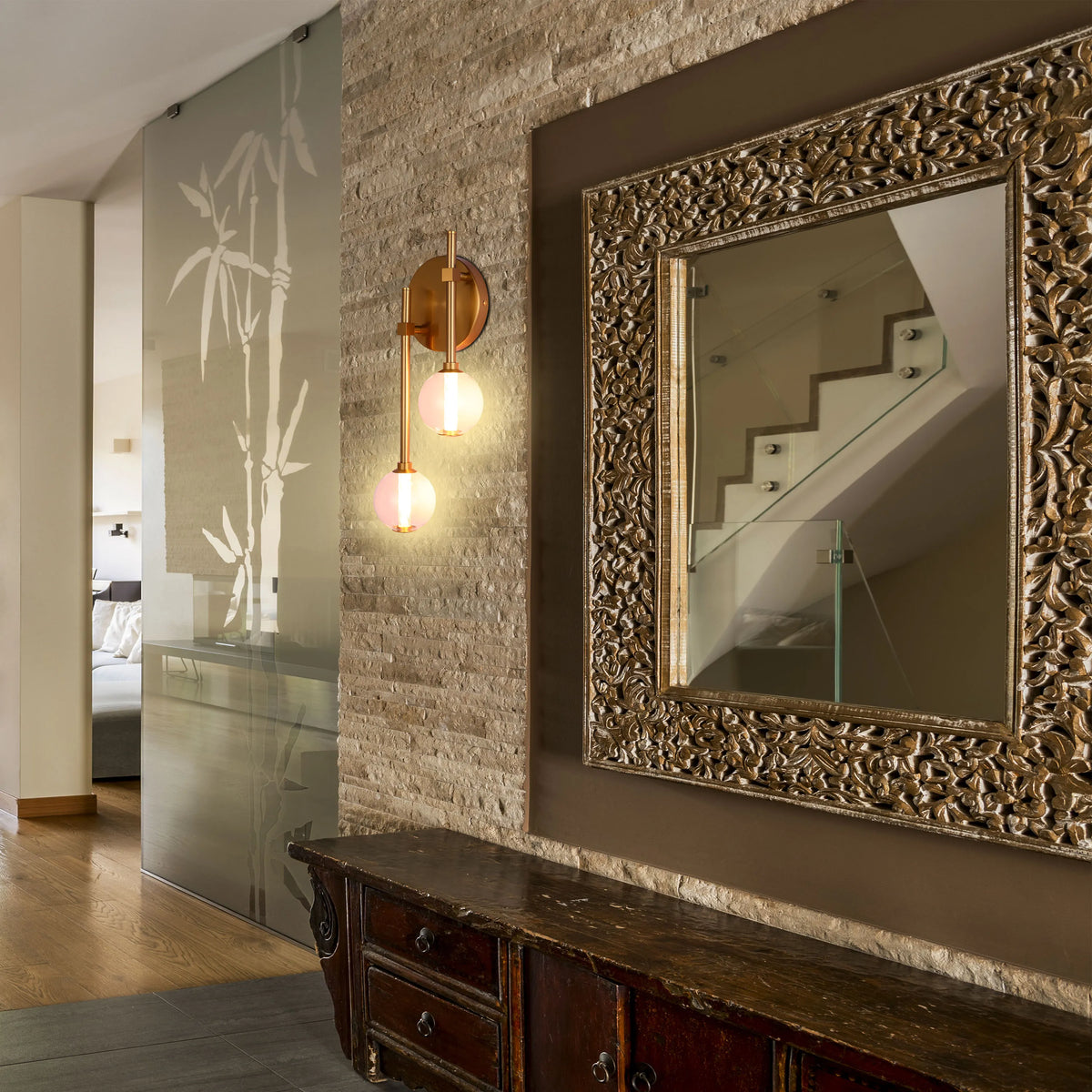 A sconce with two round lights illuminates a hallway, adding a touch of warmth and elegance to the wall decor.