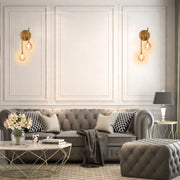 Elegant wall sconces with warm, glowing spherical shades. A classic table lamp adds soft light to this inviting living space.