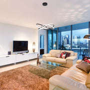 Contemporary living room featuring a striking circular pendant light in black and white, providing ambient illumination.