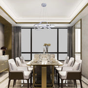 A modern ringed chandelier hangs above a formal dining table, offering stylish illumination and a focal point in the room.